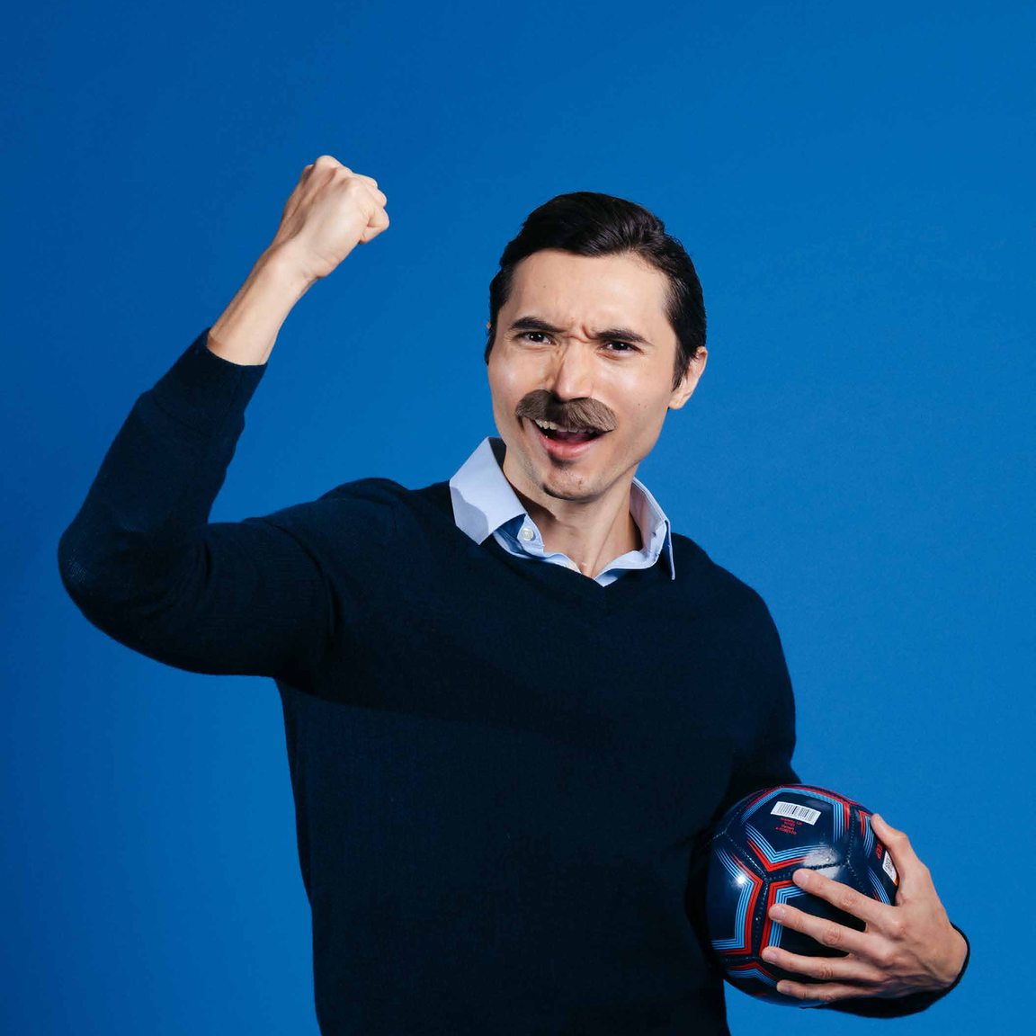 A coach costume — navy crewneck jumper and a collared shirt.